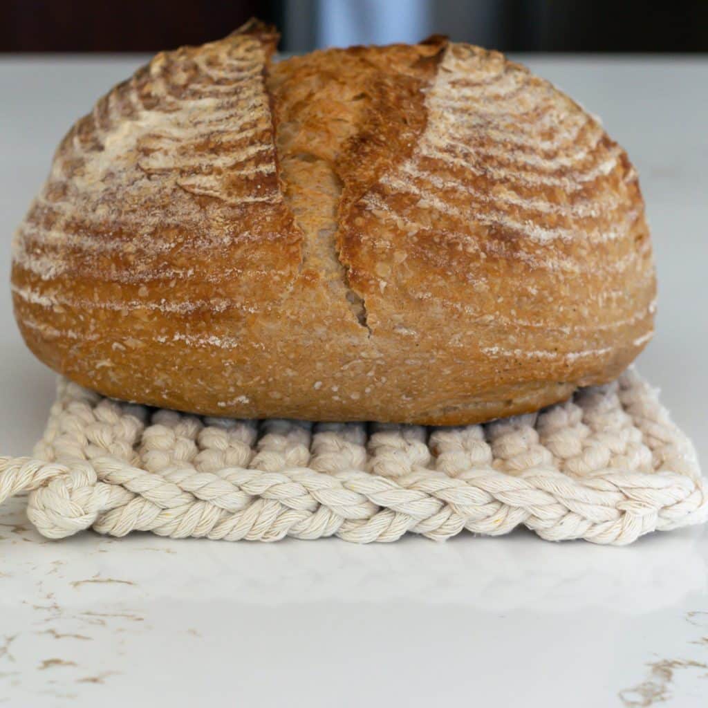 Garter stitch trivet with a loaf of bread.