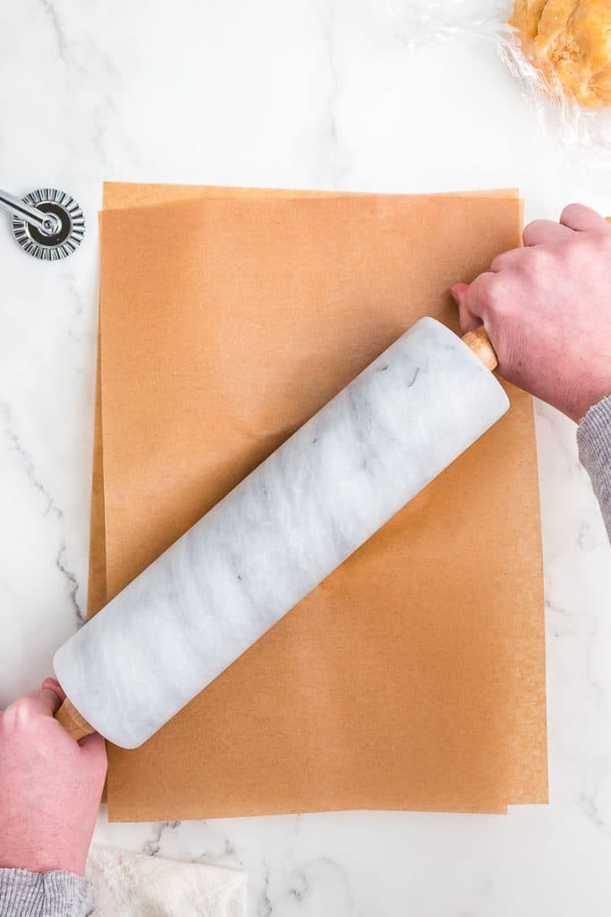 Rolling dough between parchment paper.
