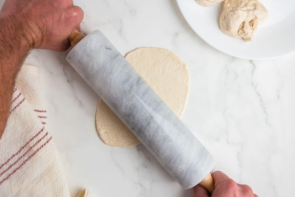 Rolling sourdough flatbread thin.