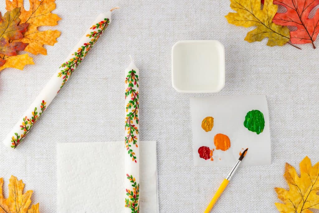 Painting leaves on candle.