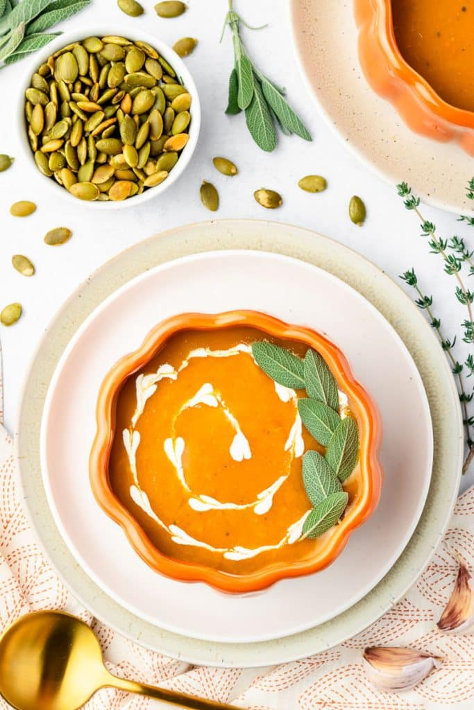 Bowl of slow cooker pumpkin soup in a pumpkin shaped bowl.