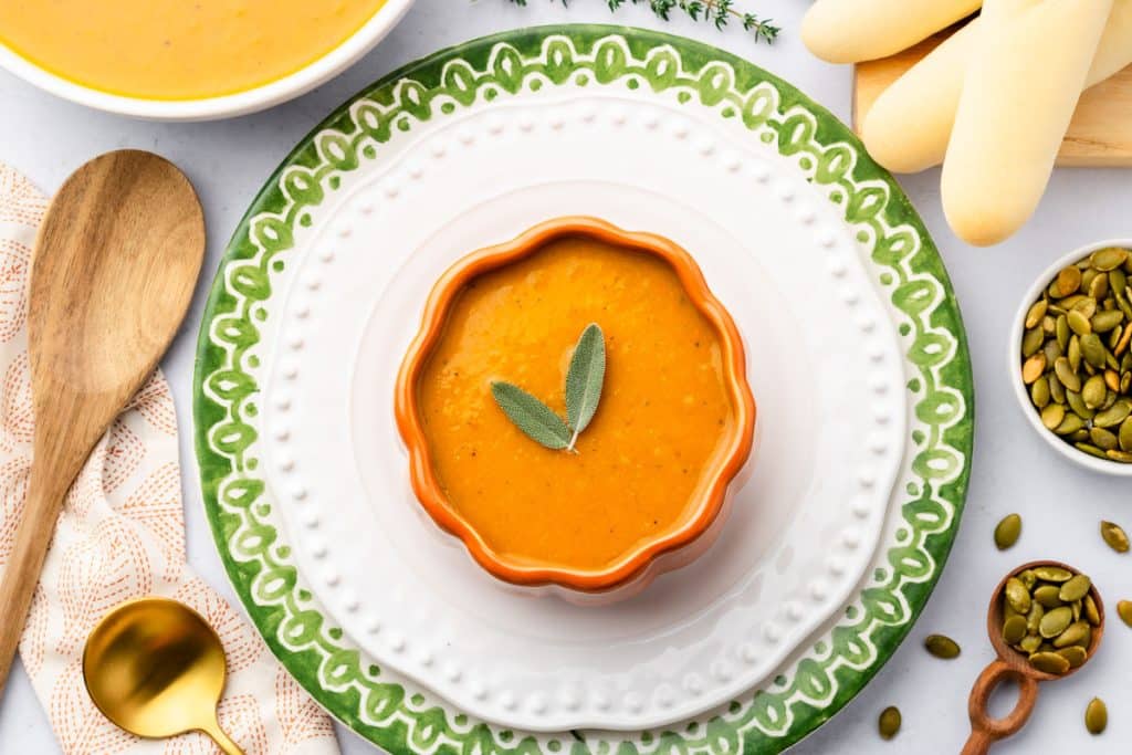 Bowl of slow cooker pumpkin soup in a pumpkin shaped bowl.