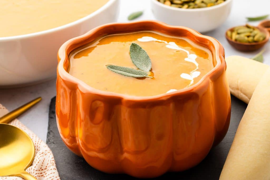 Bowl of slow cooker pumpkin soup in a pumpkin shaped bowl.