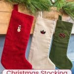 Three embroidered stockings hanging on a mantle.