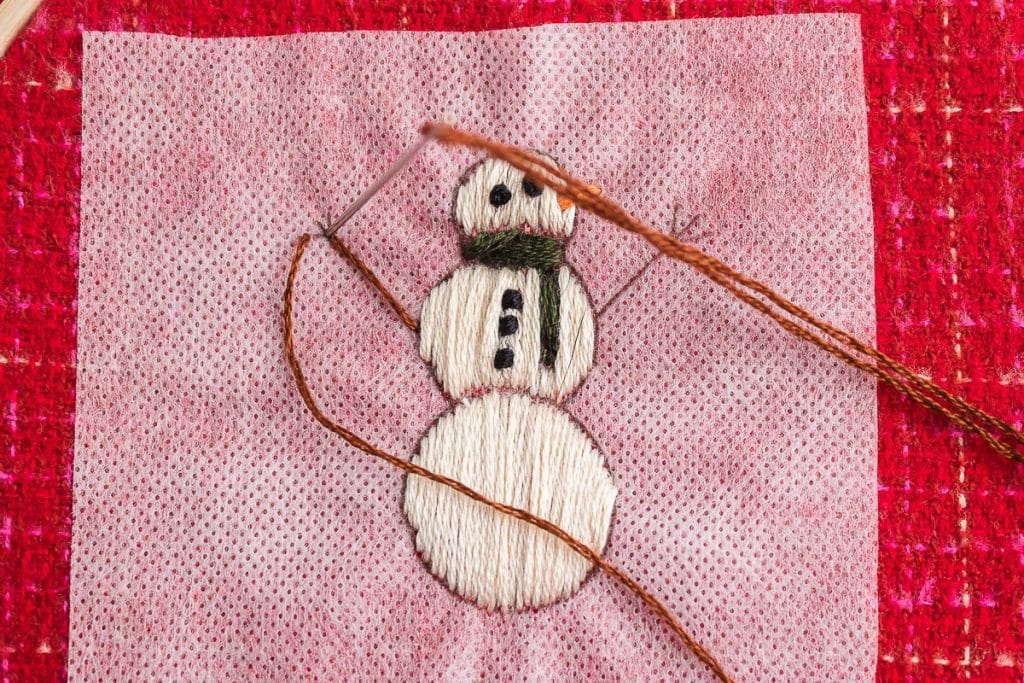 sewing arms of snowman.