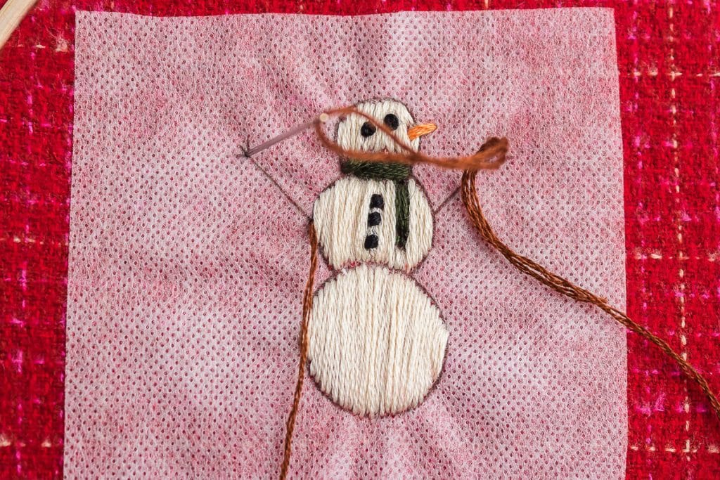 sewing arms of snowman.