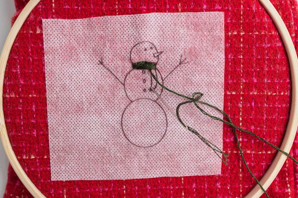 sewing scarf on snowman.