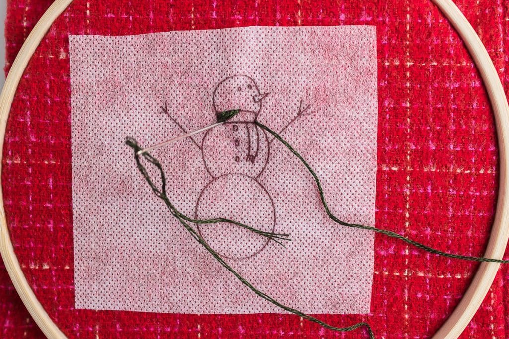 sewing scarf on snowman.