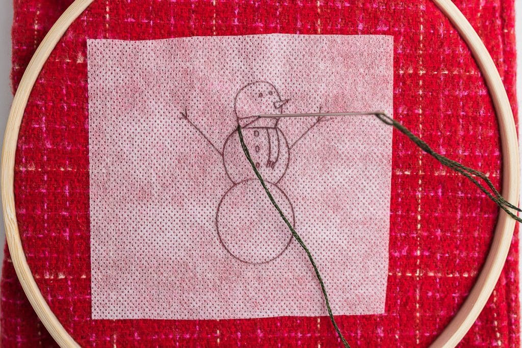 sewing scarf on snowman.