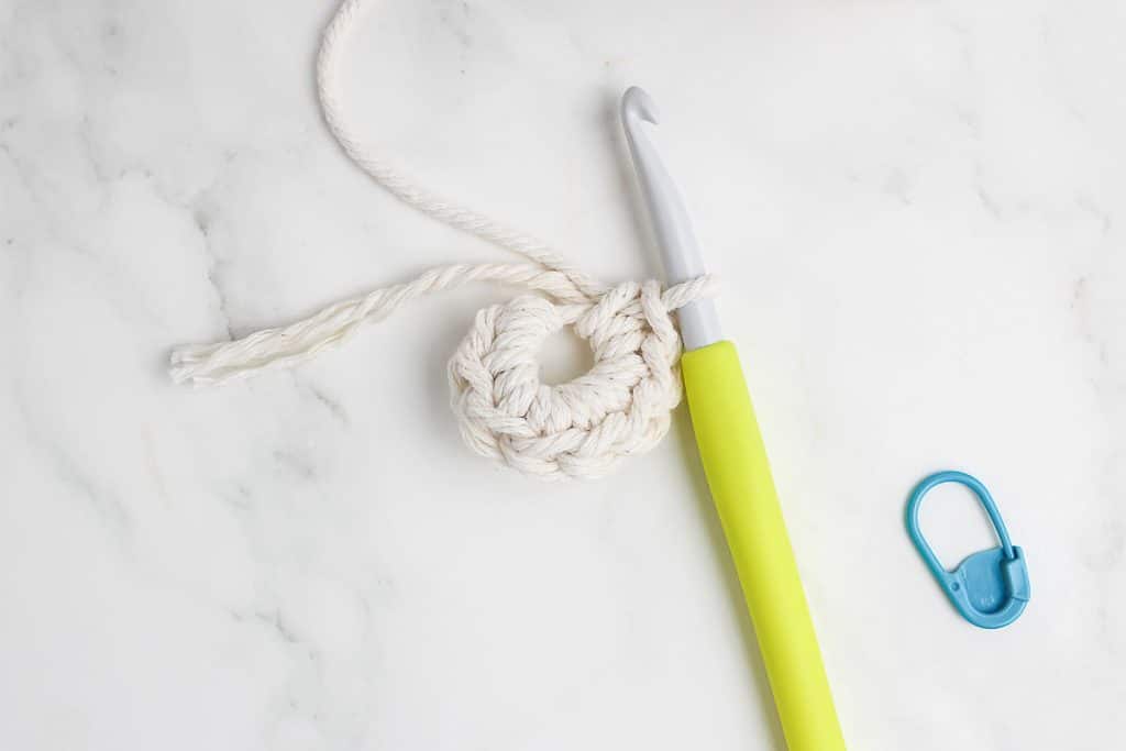 Crochet hook and rope working on magic circle.