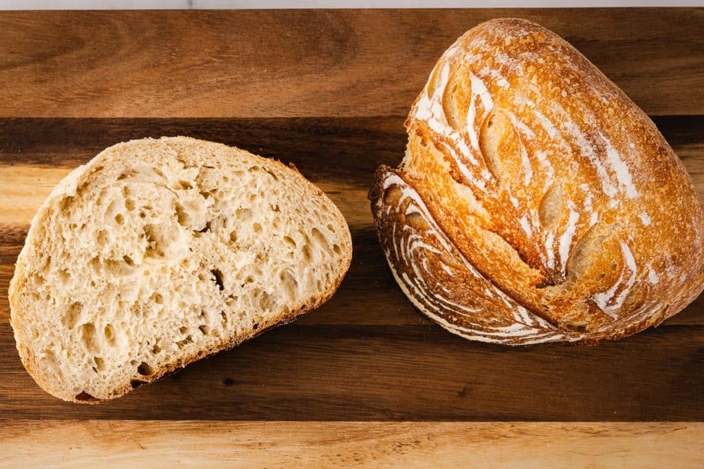 Loaf of bread and sliced bread. baked following this easy sourdough bread recipe.