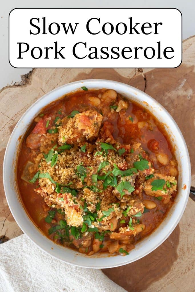 Slow cooker pork casserole in a white bowl on a slab of wood.