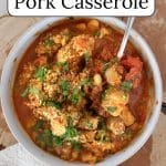 Slow cooker pork casserole in a white bowl on a slab of wood.