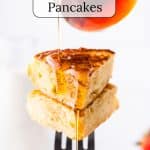 Stack of pancakes on a fork with syrup.