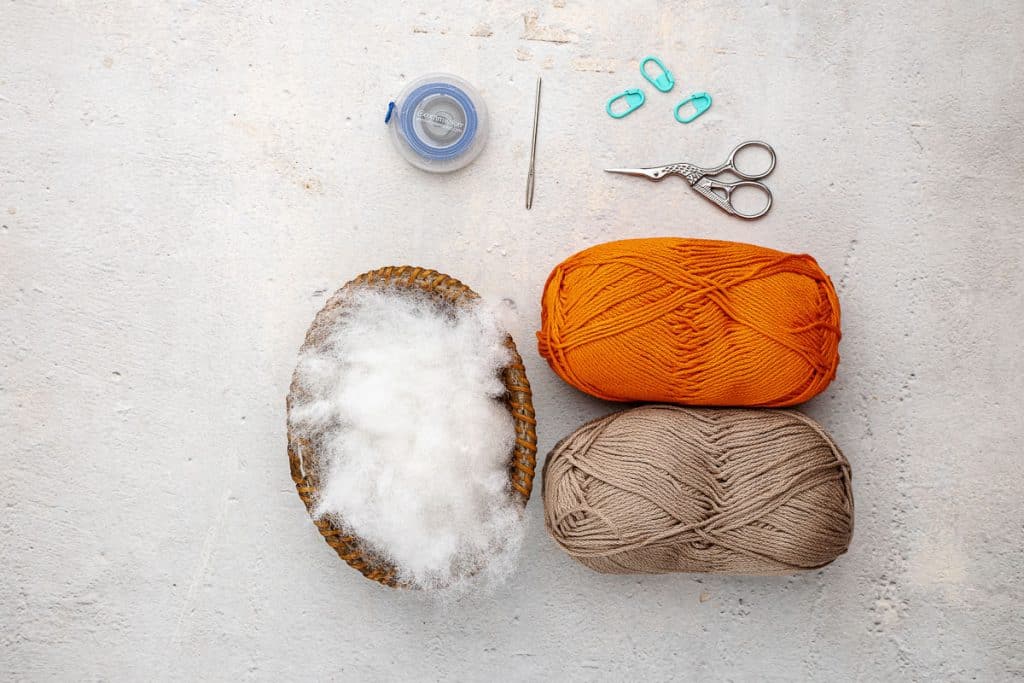 Yarn, polyfill, scissors, and tapestry needle.