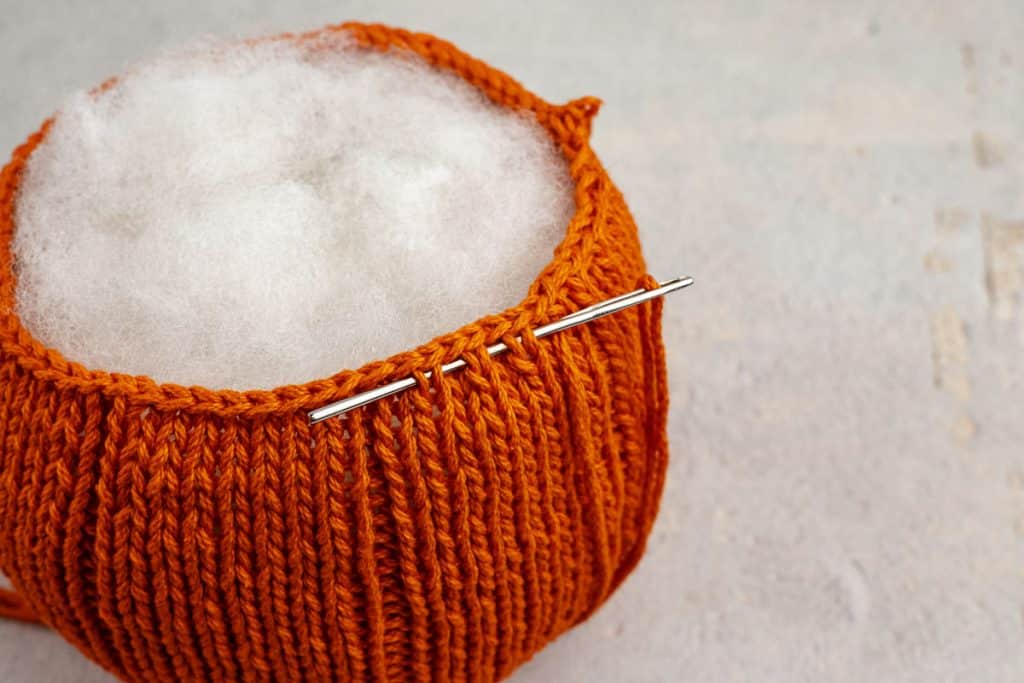 Needle through edge of pumpkin.