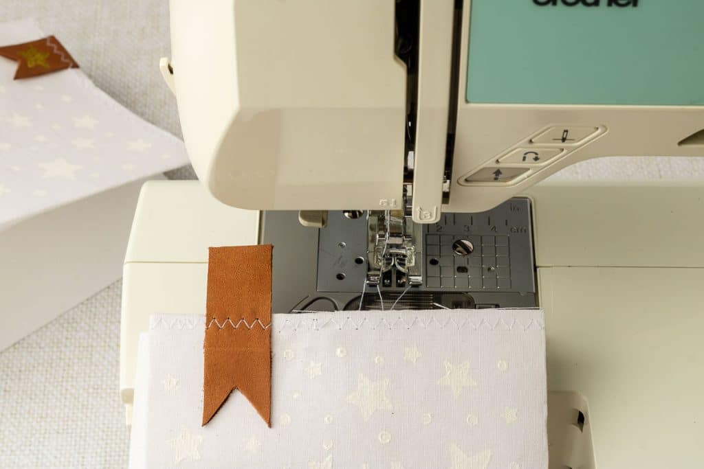 Zig zag along the top of bag.