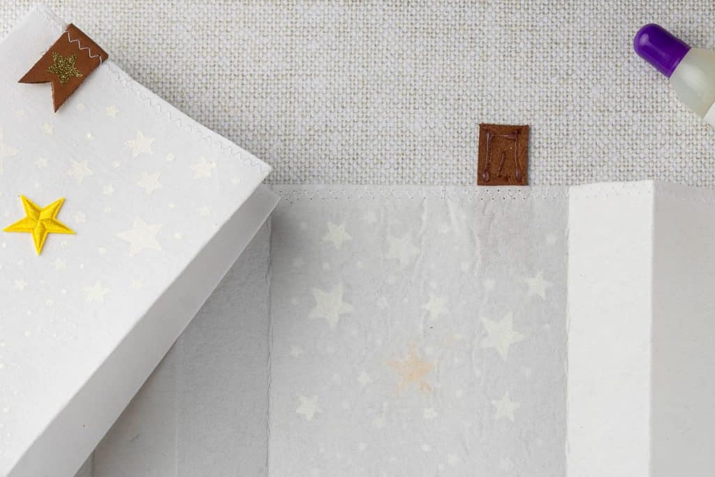 Glue and fold over leather tab.