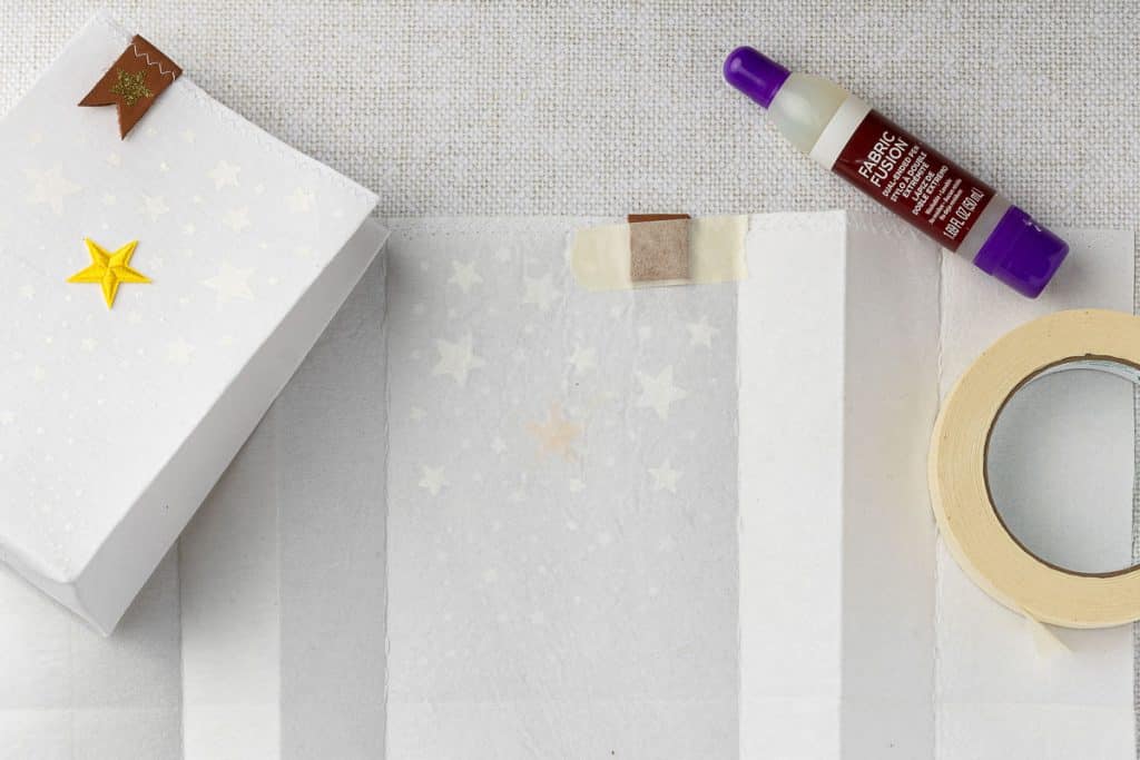 Use tape to secure leather tab while it dries.