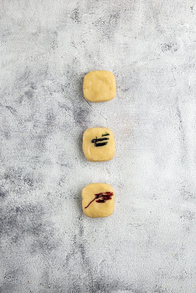 Adding food color to cookie dough.