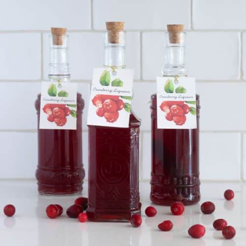 Bottles of cranberry liqueur with gift tags.