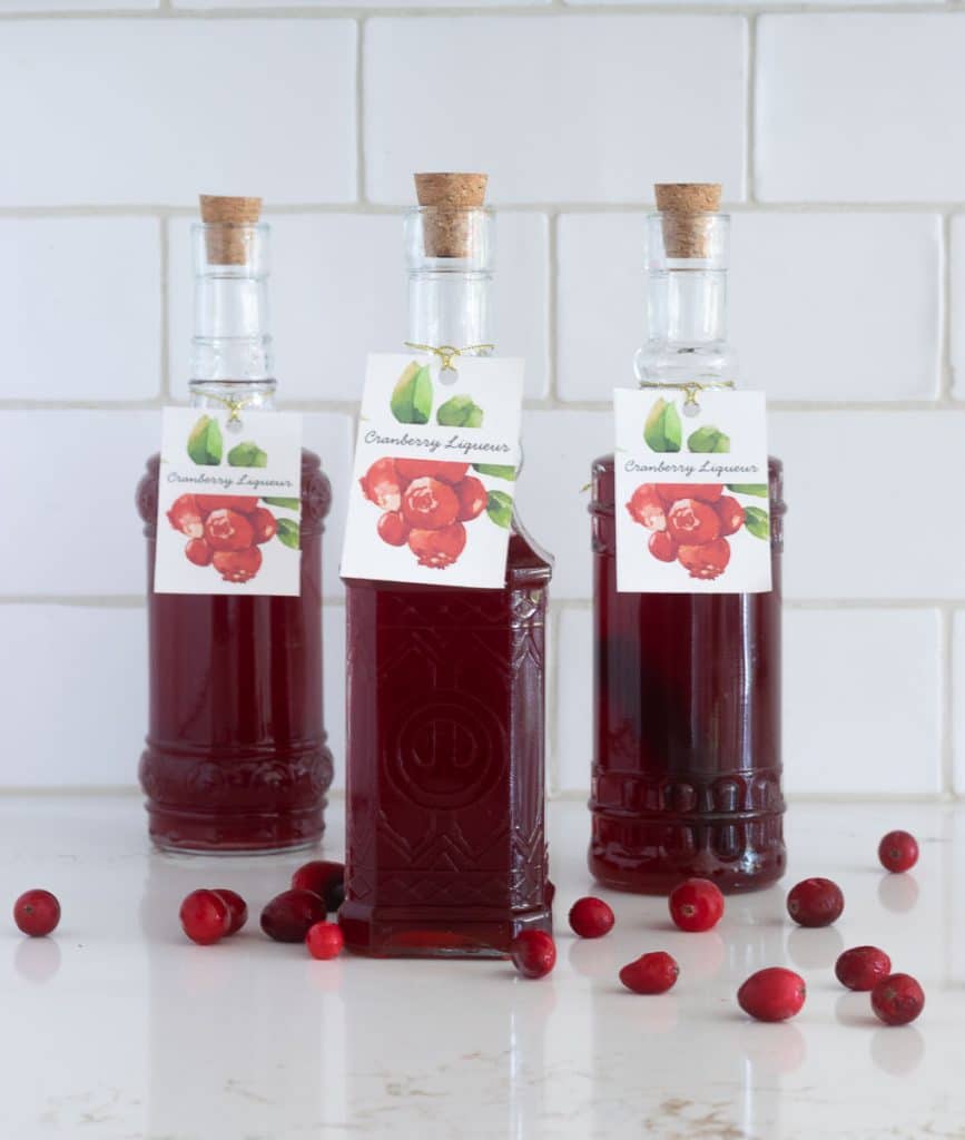 Bottles of cranberry liqueur with gift tags.