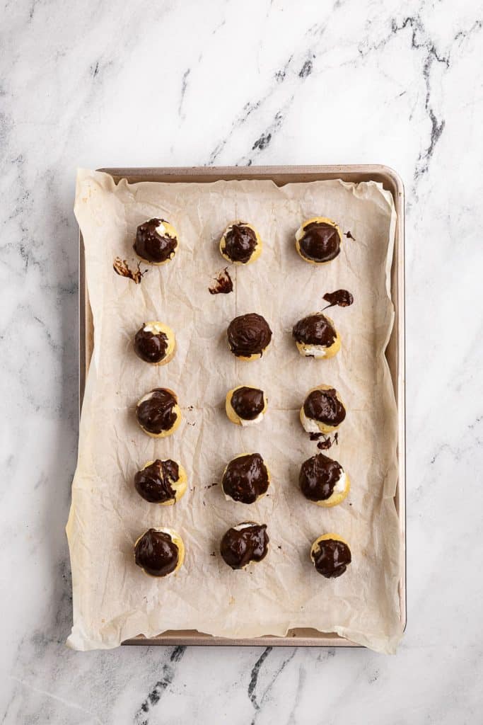 Profiteroles dipped into chocolate.
