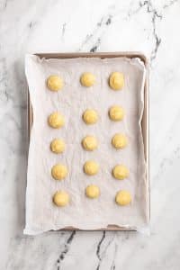 Piped Macarons on sheet of parchmetn paper.