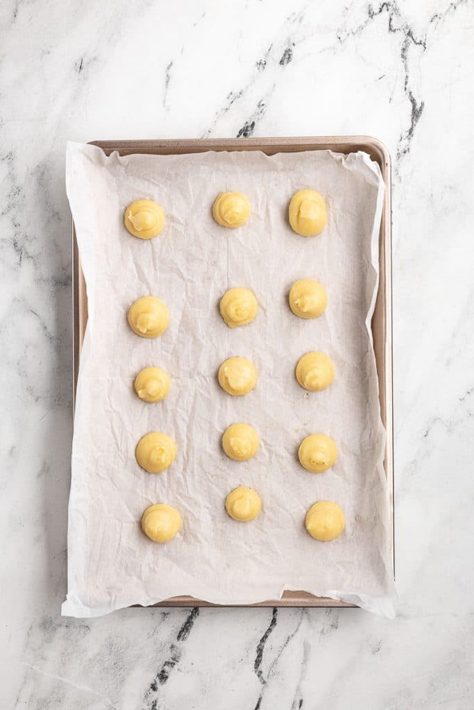 Piped Macarons on sheet of parchmetn paper.