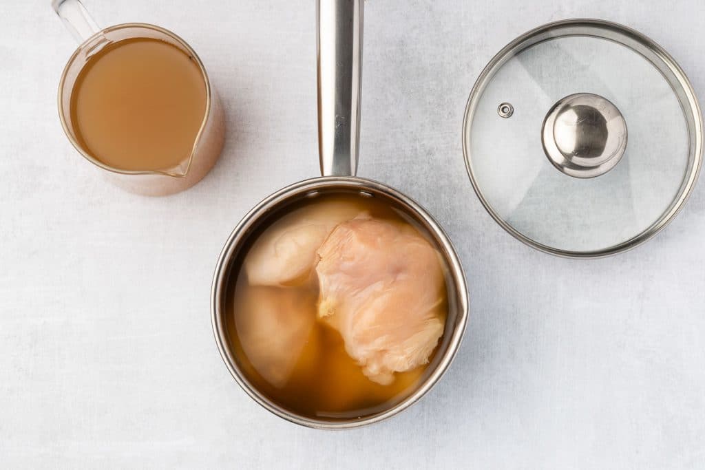 Raw chicken in broth.