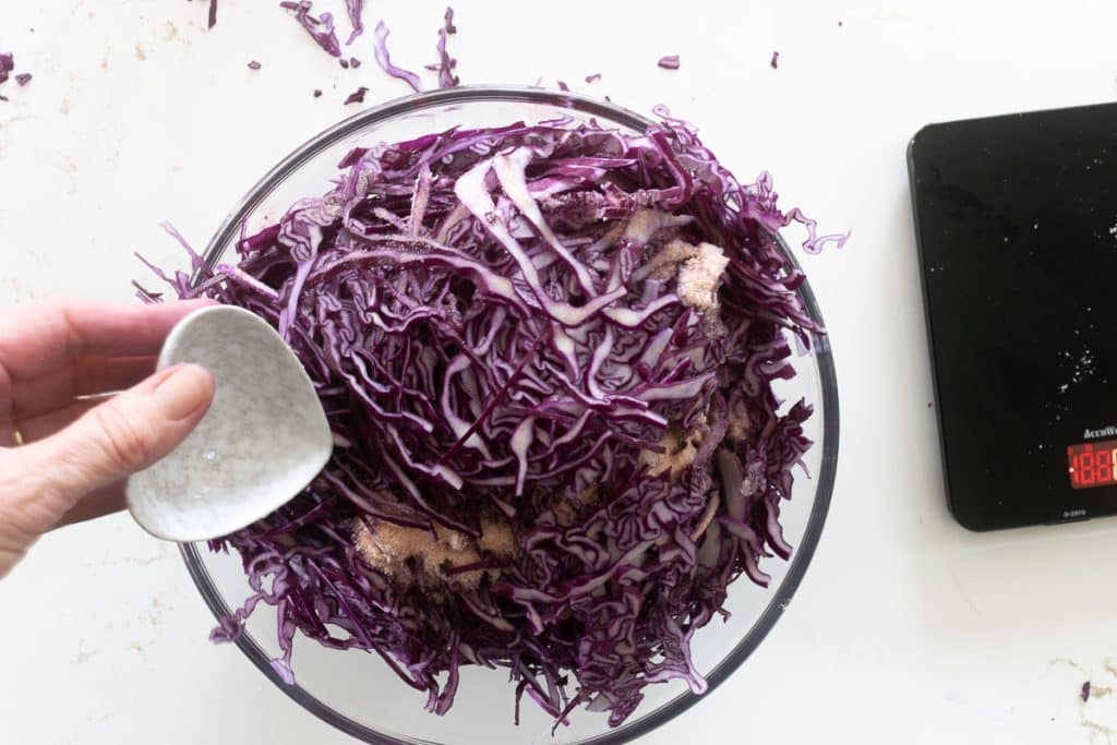 Adding salt to veggies.