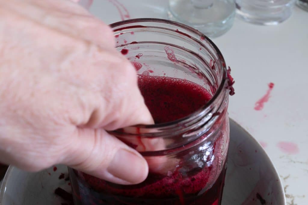 Pushing down ingredients into jar.