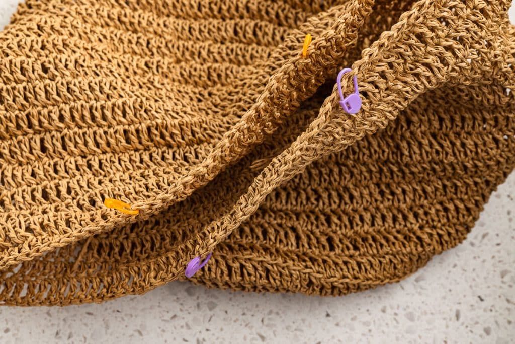 Stitch markers on raffia crochet beach bag.