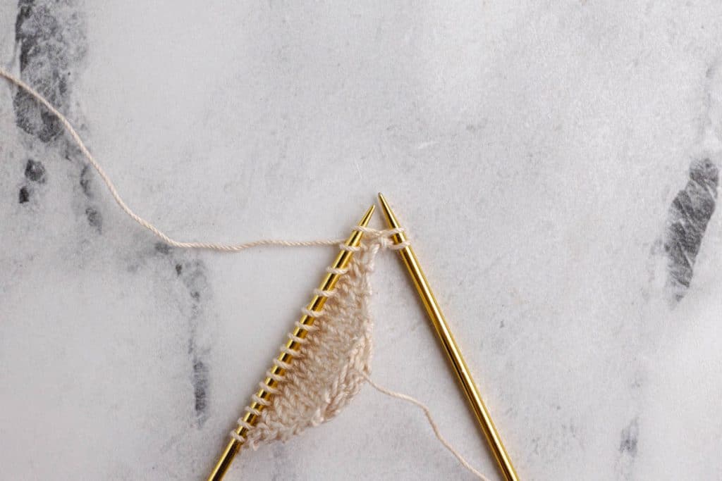 Showing how to do eyelet increases on the sides.