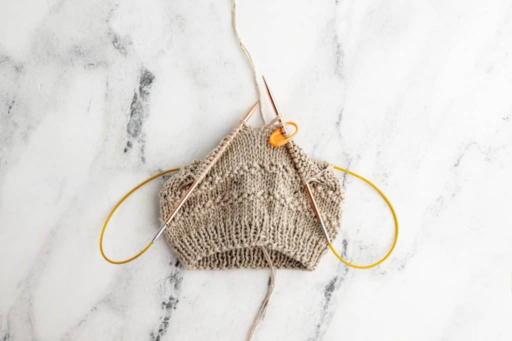 Working seed trim on knit baby hat.