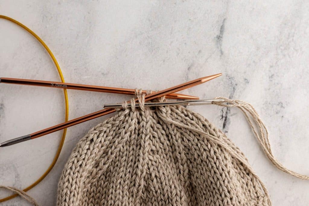 Closing seams of baby hat.