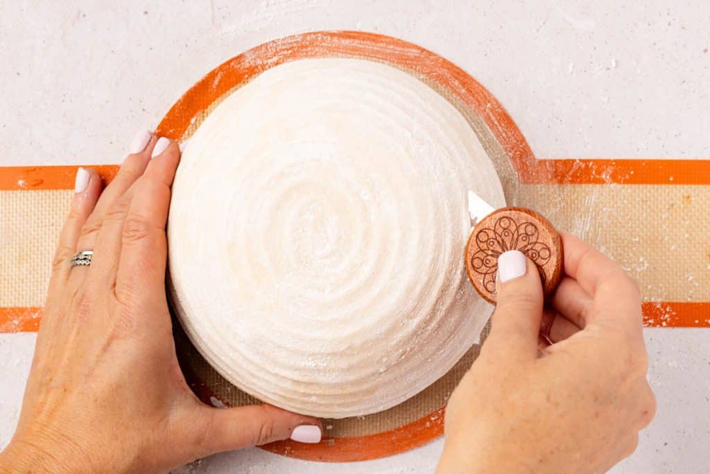 Use lame to score dough at a 45 degree angle.